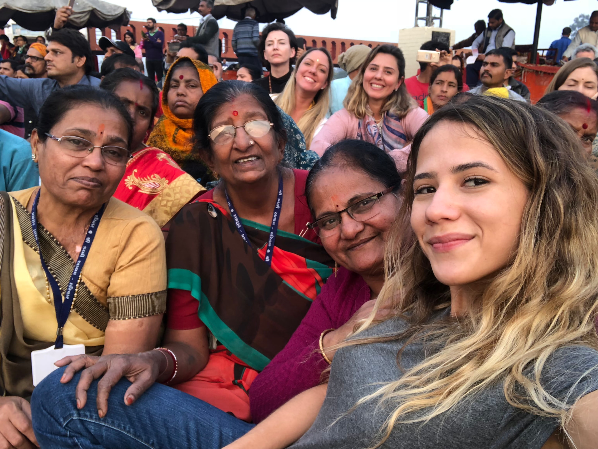 Nina entre mulheres indianas durante uma cerimônia à beira do rio
