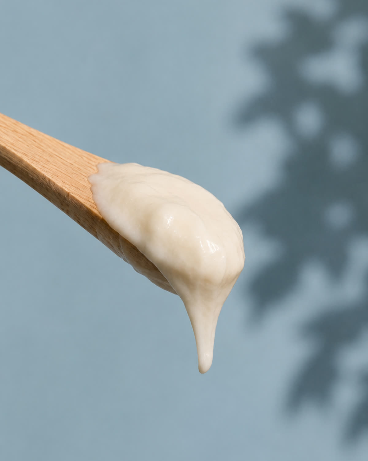 Textura de creme ayurvédico em espátula de madeira